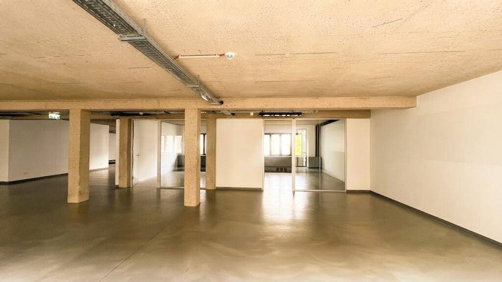 Großer, offener Bürobereich mit Betonstützen und Glasabtrennungen, der viel Flexibilität in der Raumgestaltung bietet.