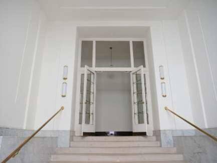 Heller und geräumiger Eingangsbereich mit Marmortreppe, hohen Decken und großen Flügeltüren.