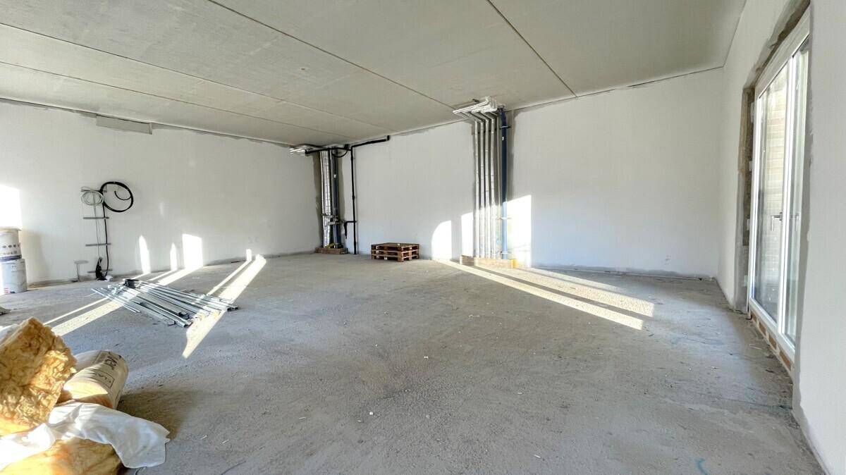 Großer Rohbau-Raum mit Baumaterialien und sichtbaren Installationen, bereit für den weiteren Ausbau.