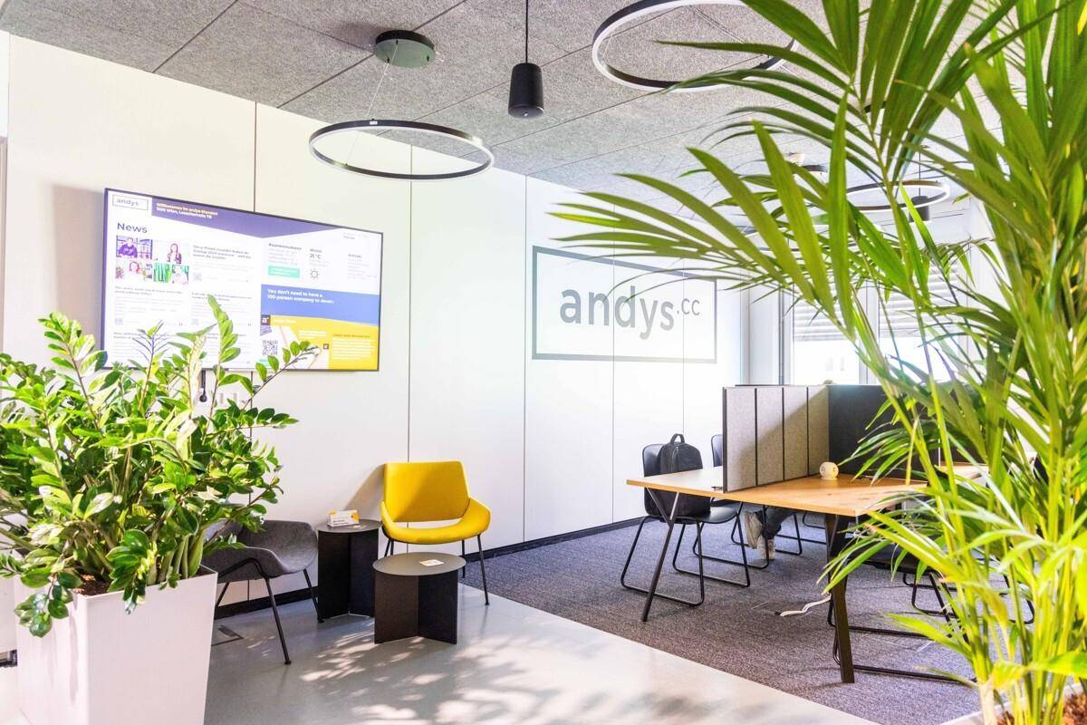 Empfangsbereich oder Loungebereich in einem modernen Büro mit bequemen Sitzgelegenheiten und Pflanzen.