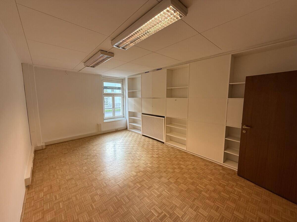 Büro mit Parkettboden und umfangreichen Einbauschränken, ideal für Organisation und Effizienz.