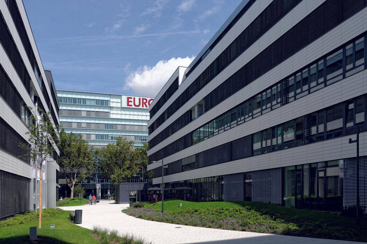 Moderner Bürokomplex mit großen Fenstern und einem Schriftzug an einem der Gebäude.