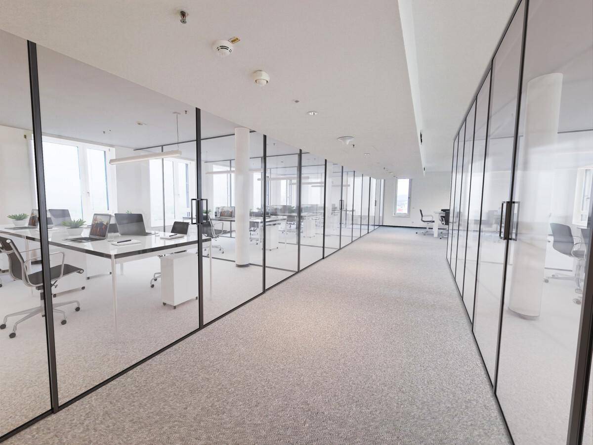 Langer Bürogang mit Glaswänden, die separate Arbeitsbereiche abgrenzen und viel Licht hereinlassen.