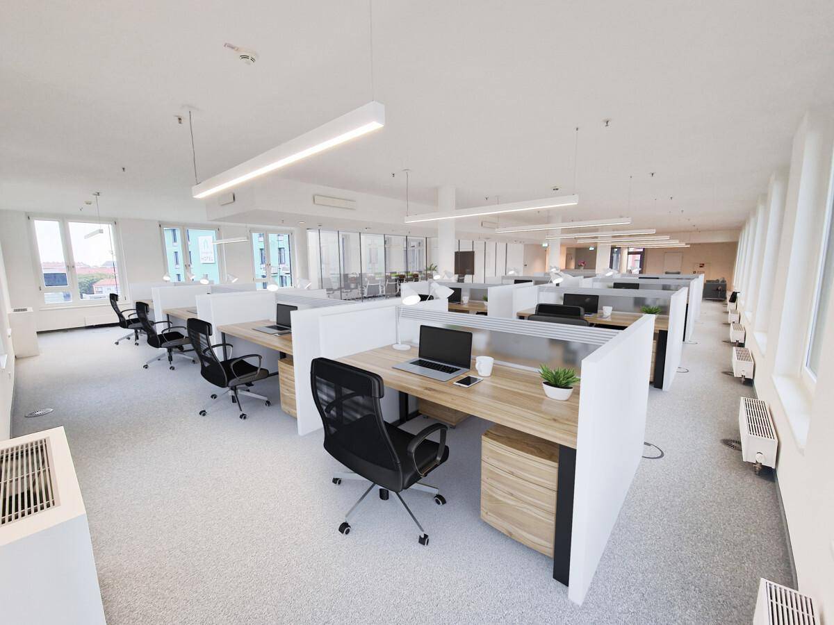 Großes, offenes Büro mit modernen Schreibtischen, ergonomischen Stühlen und viel natürlichem Licht.