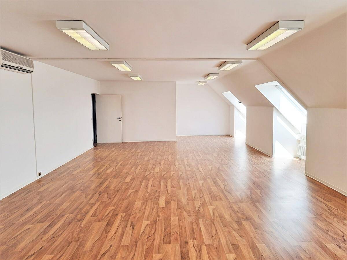 Geräumiger, heller Raum mit Laminatboden, Dachschrägen und mehreren Dachfenstern, inklusive Klimaanlage.