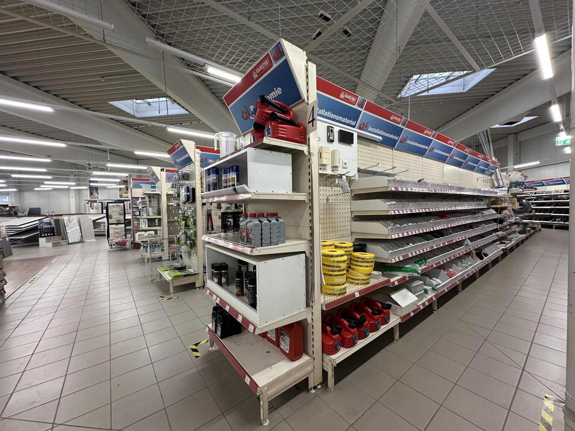 Regale mit verschiedenen Produkten und Baumaterialien in einem gut sortierten Verkaufsraum.