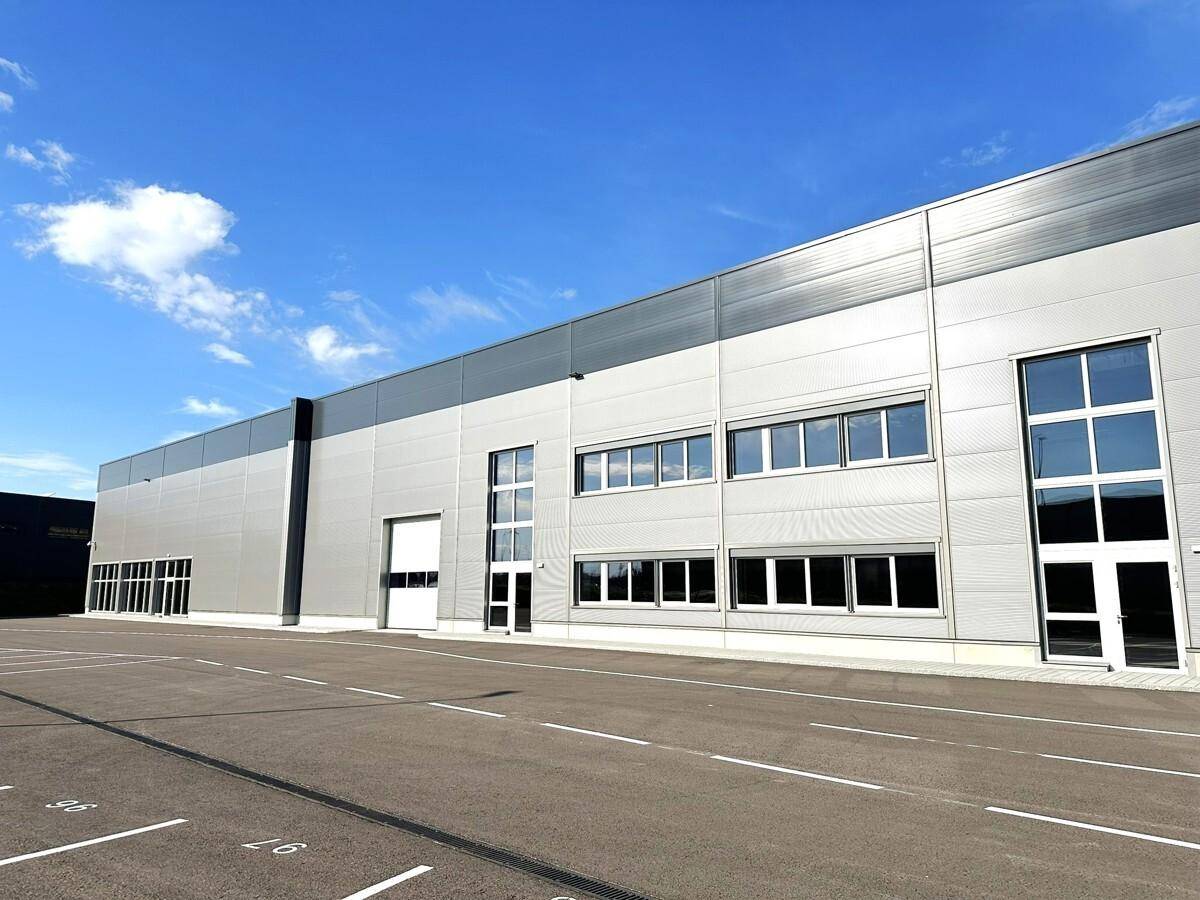 Detailansicht der modernen Fassade eines Gewerbegebäudes mit verschiedenen Fenstergrößen.