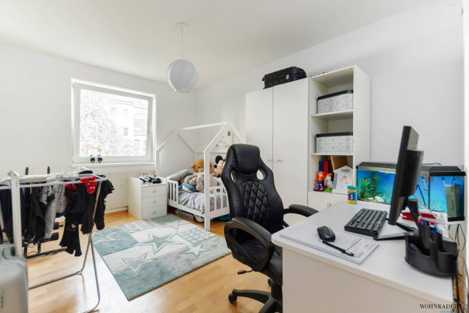 Kinderzimmer mit Schreibtisch, Bett und Schrank, ideal als Spiel- oder Arbeitsbereich.