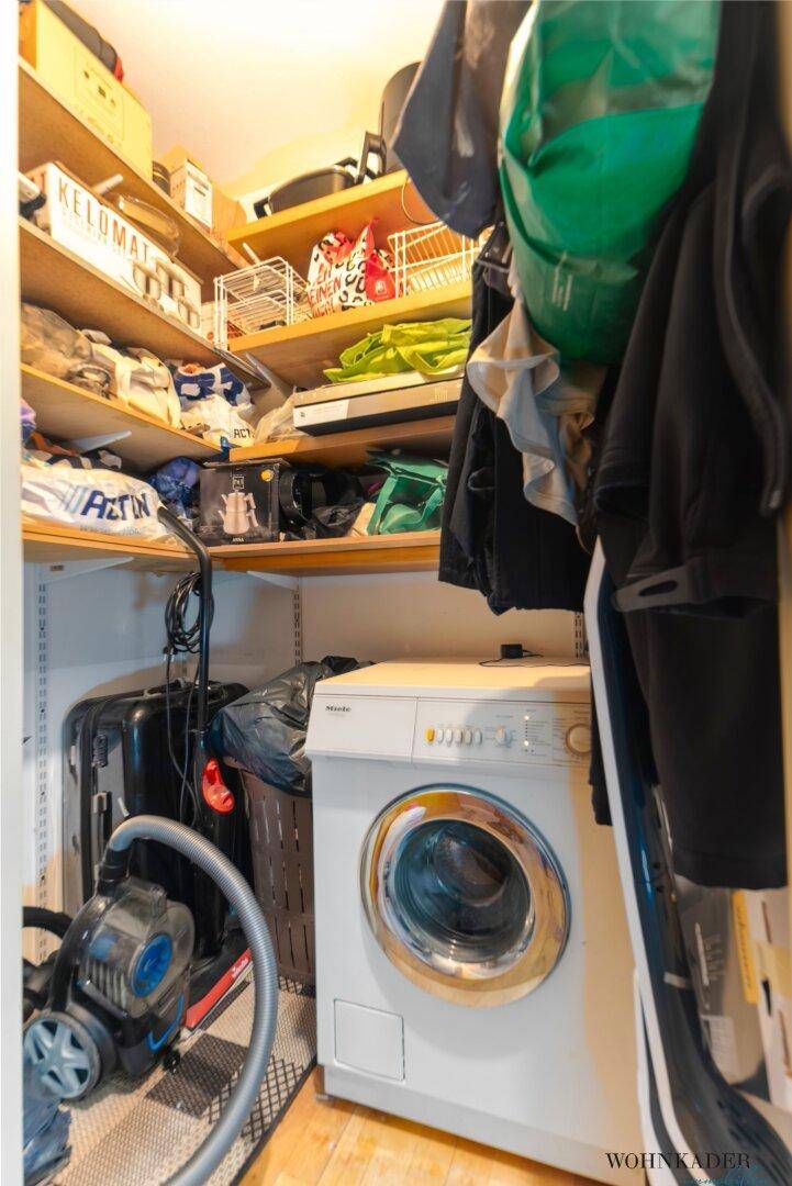 Praktischer Abstellraum mit Regalen, Waschmaschine und Stauraum für Haushaltsgeräte.