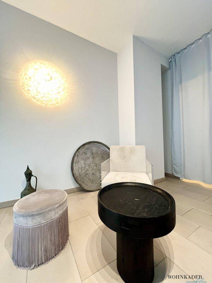 Modernes Gäste-WC mit wandhängender Toilette und hellen Fliesen an Wänden und Boden.