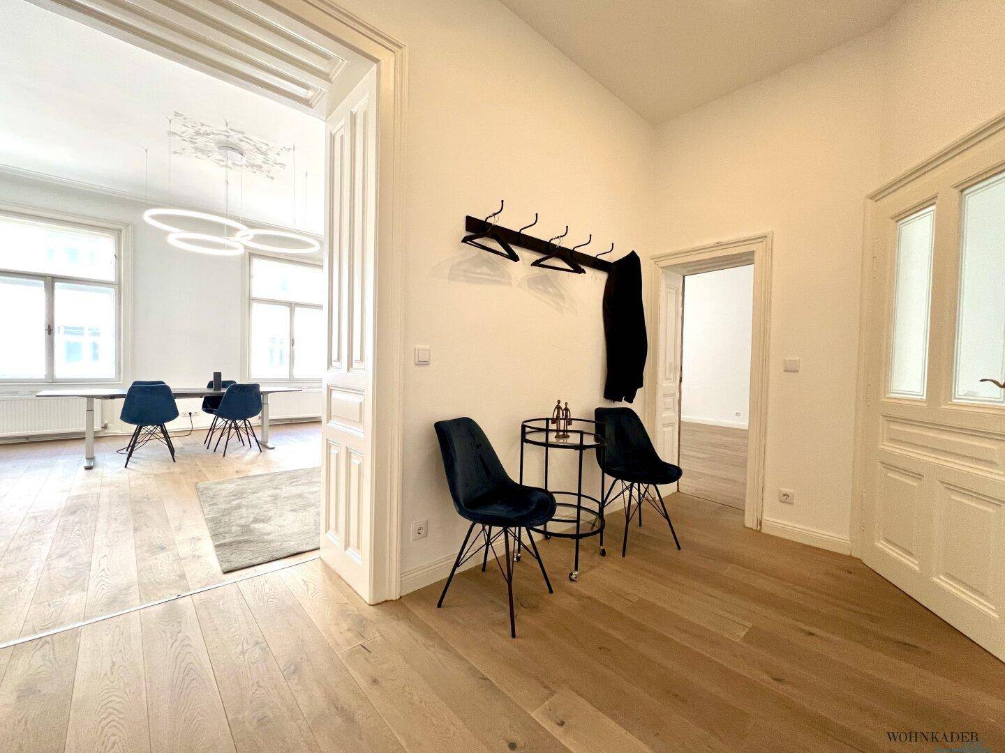 Heller Flur mit Garderobe und Sitzgelegenheiten, der in den geräumigen Bürobereich führt.