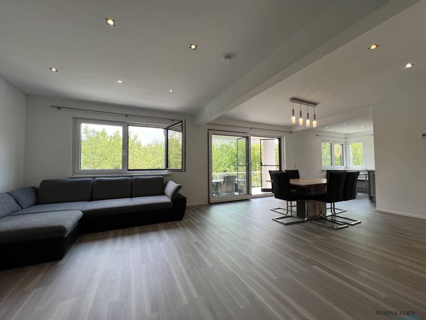 Heller Wohn-Essbereich mit Sofa und Esstisch, offen gestaltet und mit Terrassenzugang.