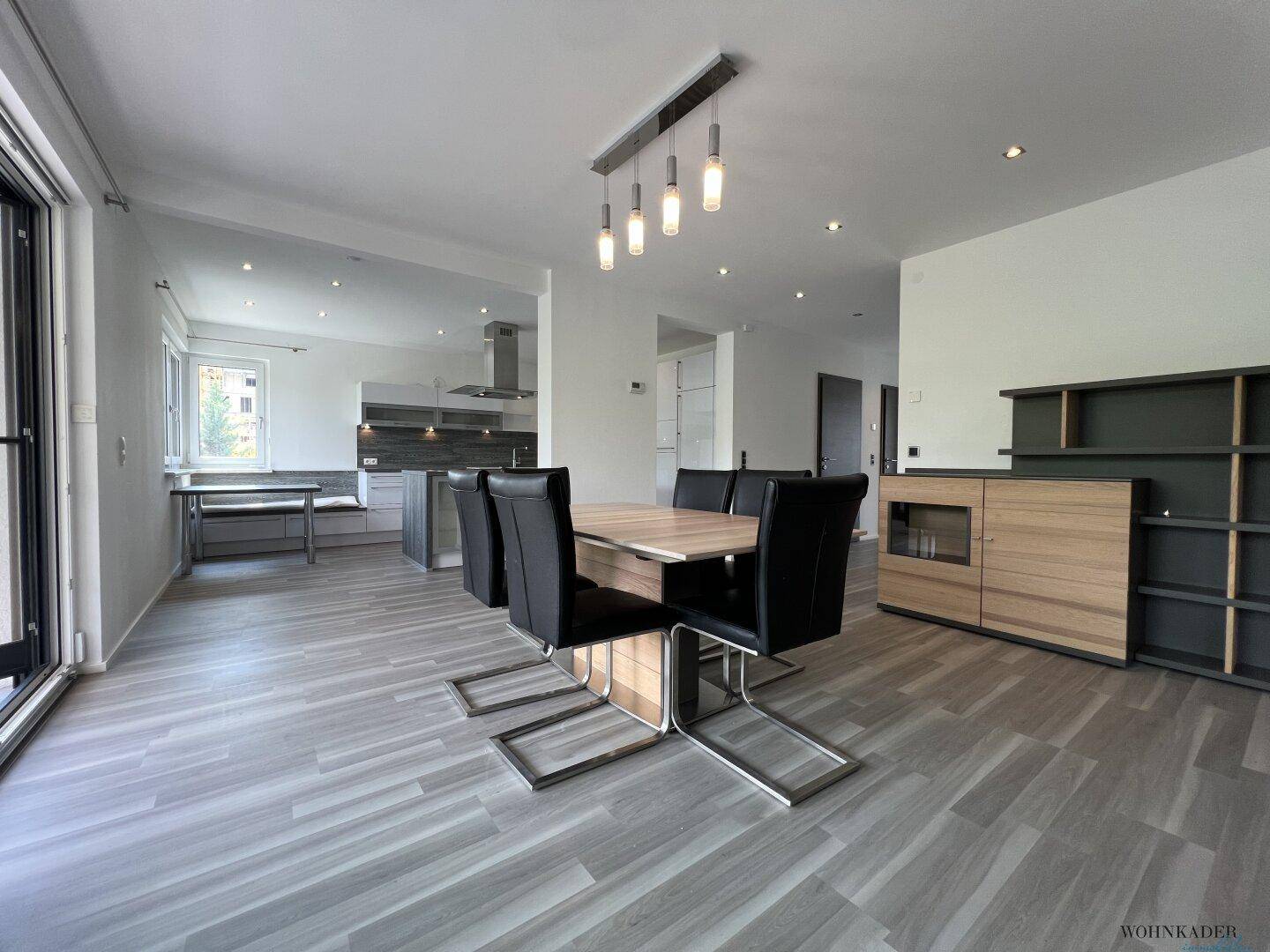 Heller Essbereich mit modernem Tisch und Stühlen, offen zur Küche und mit Terrassenzugang.