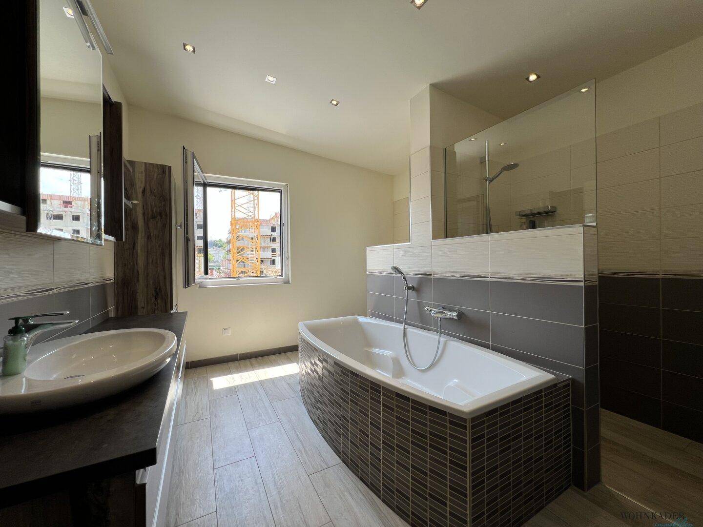 Modernes Badezimmer mit Badewanne, begehbarer Dusche und eleganten Fliesen, bietet Komfort und Stil.