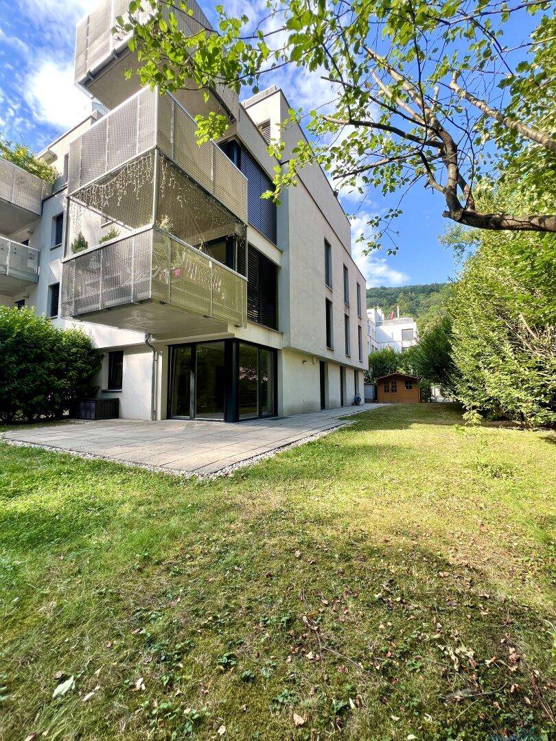 Modernes Wohngebäude mit gepflegtem Gartenbereich und einer großzügigen Terrasse.