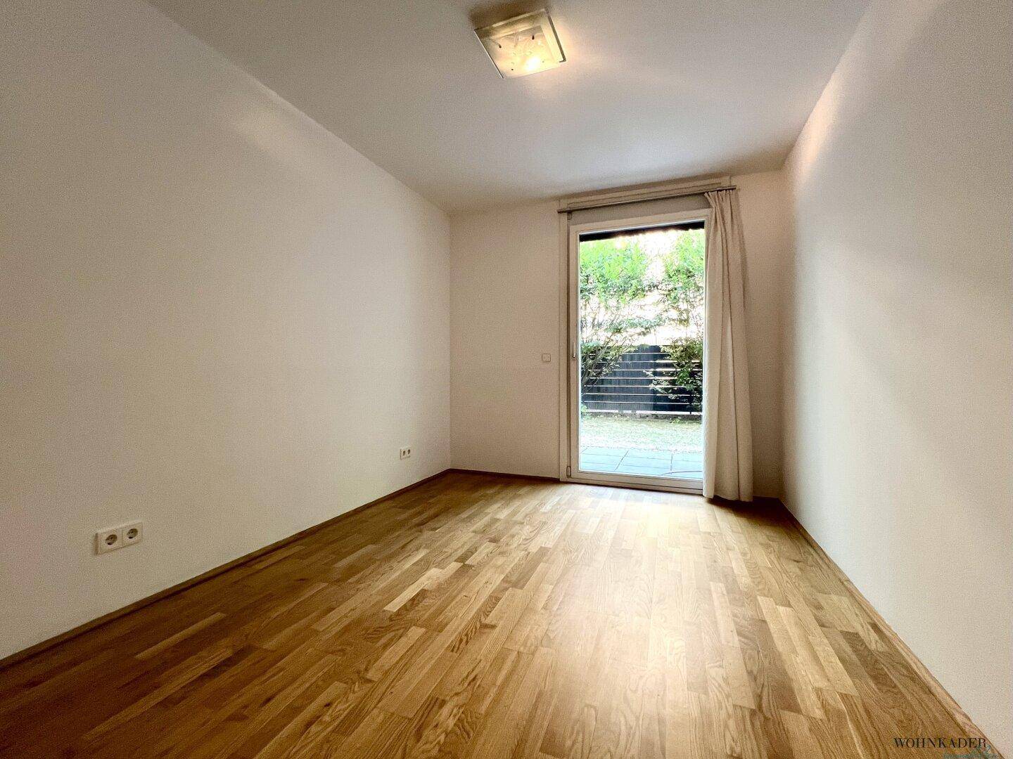 Helles Schlafzimmer mit Parkettboden und direktem Zugang zur Terrasse oder zum Garten.