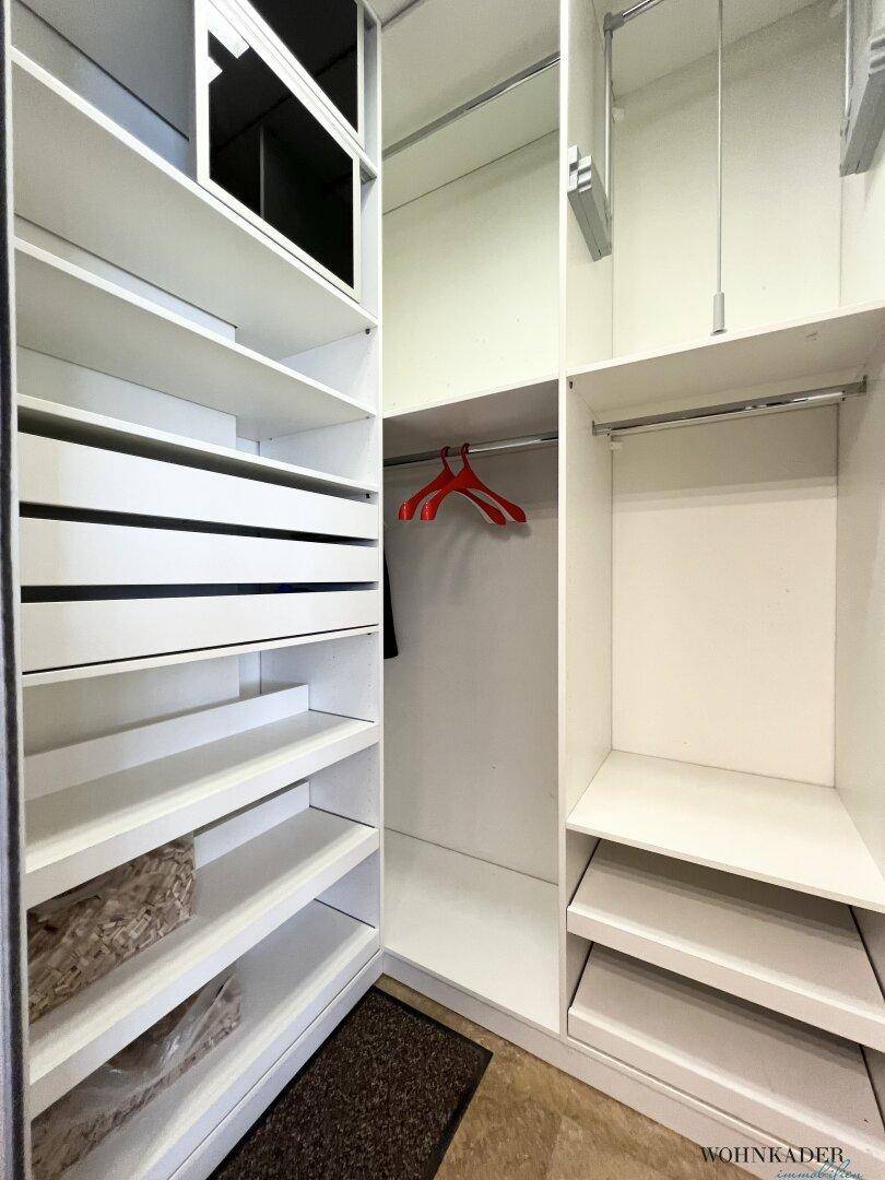 Begehbarer Kleiderschrank mit weißen Regalen und vielseitigem Stauraum.