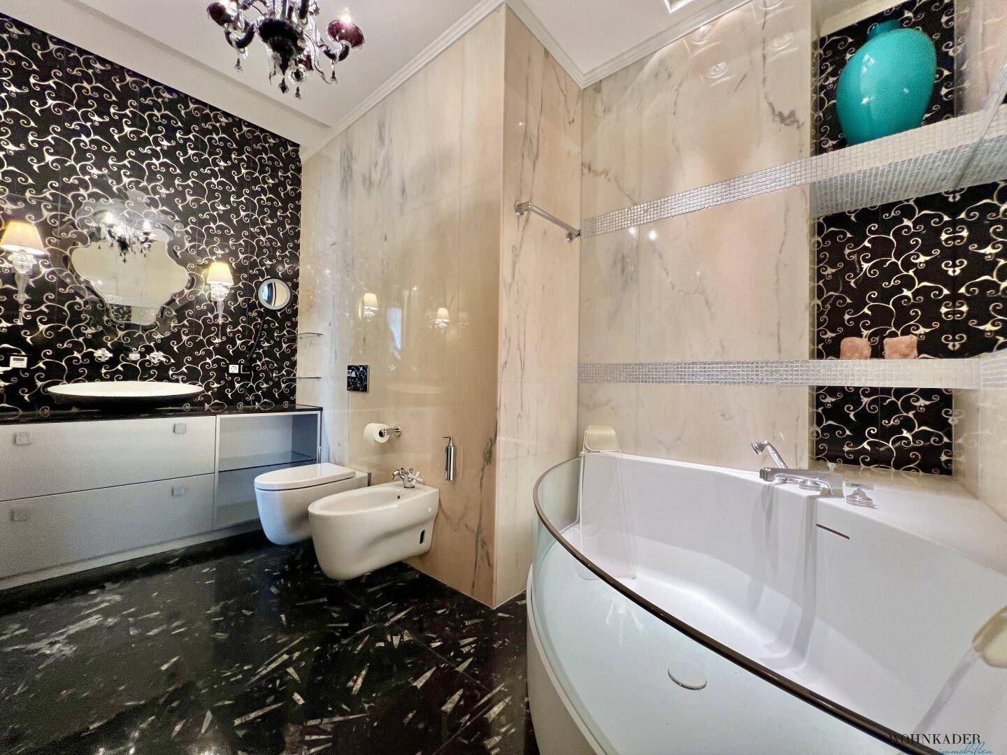 Geräumiges Badezimmer mit Badewanne, Bidet und stilvoller Wandgestaltung.