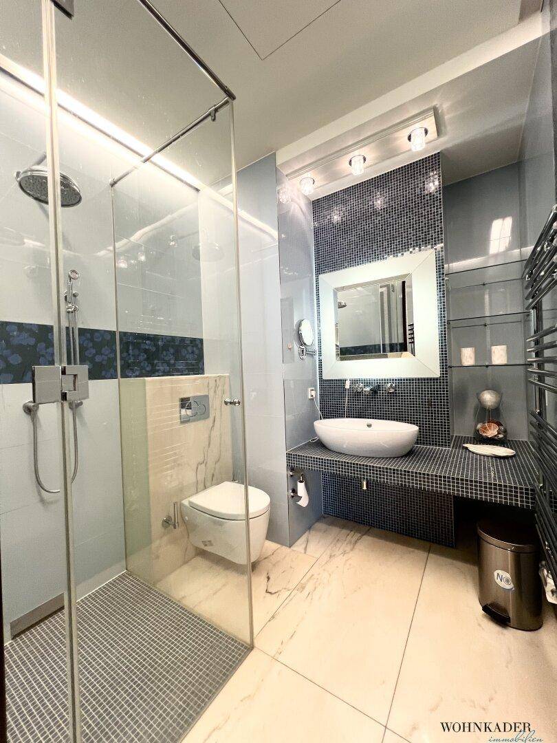 Modernes Badezimmer mit begehbarer Dusche, Mosaikfliesen und Waschtisch.