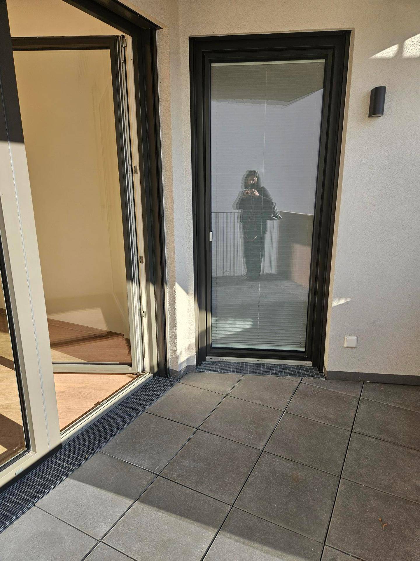 Sonnenverwöhnter Balkon mit Fliesenboden und Blick auf die Umgebung.