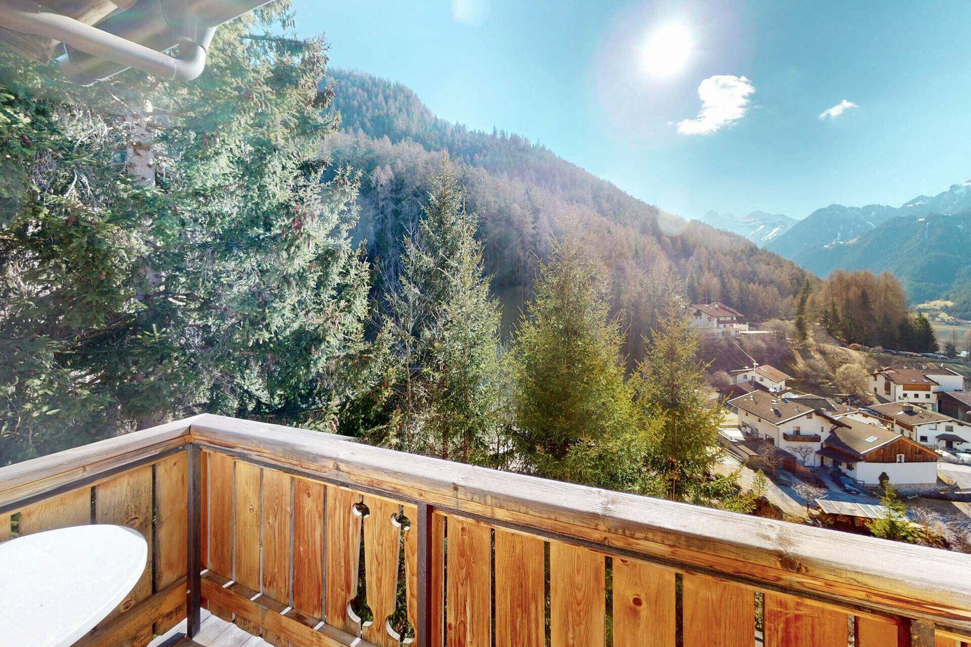 Sonniger Balkon mit Blick auf die bewaldeten Berge und das Tal.