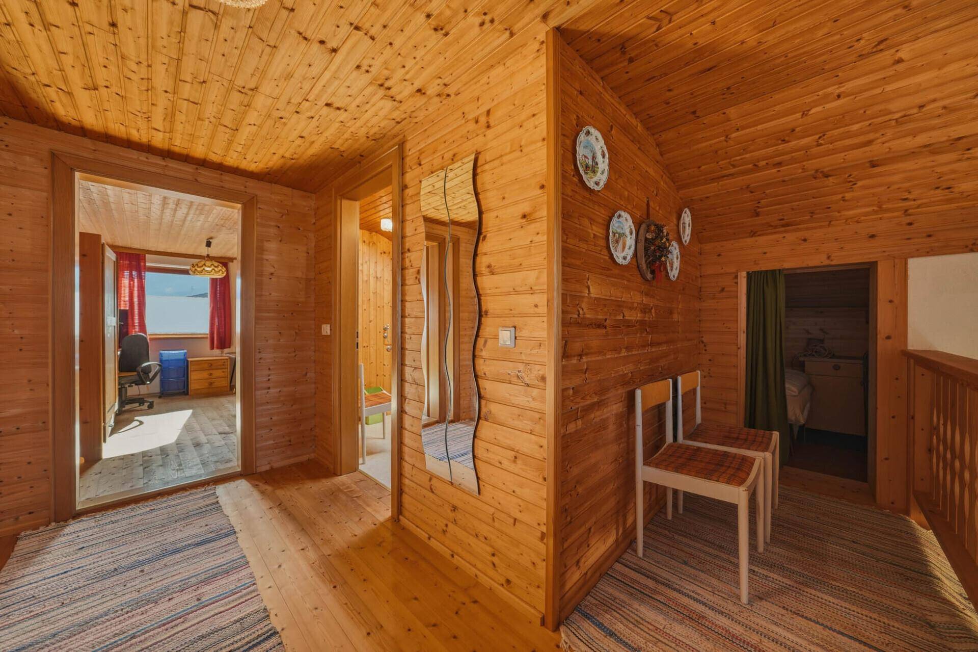 Flur mit Holztäfelung, Holzfußboden und Zugang zu weiteren Zimmern.