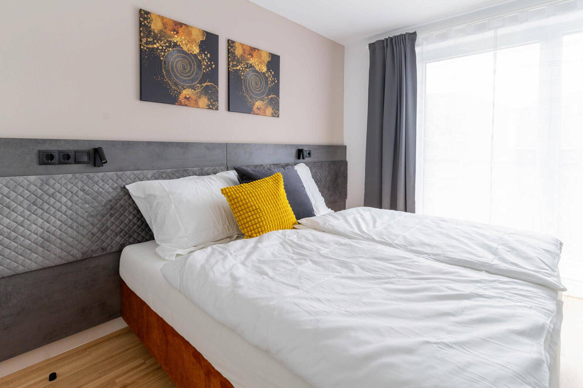 Schlafzimmer mit Doppelbett, Holzboden und einem Kleiderschrank.