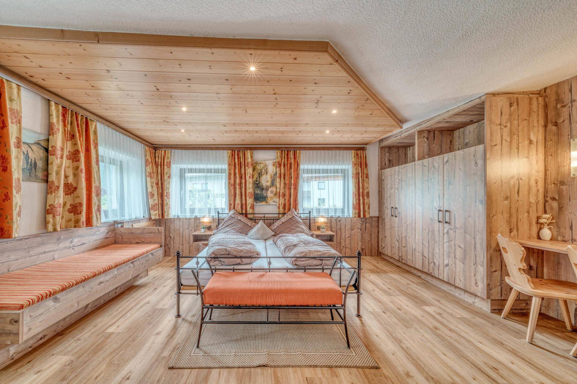 Geräumiges Schlafzimmer mit Doppelbett, Holzdecke und viel Stauraum, hell und komfortabel.