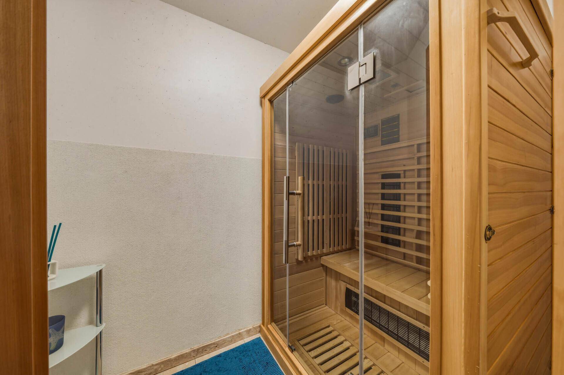 Moderne Sauna mit Holzbänken und Glastür, perfekt zum Entspannen nach einem langen Tag.