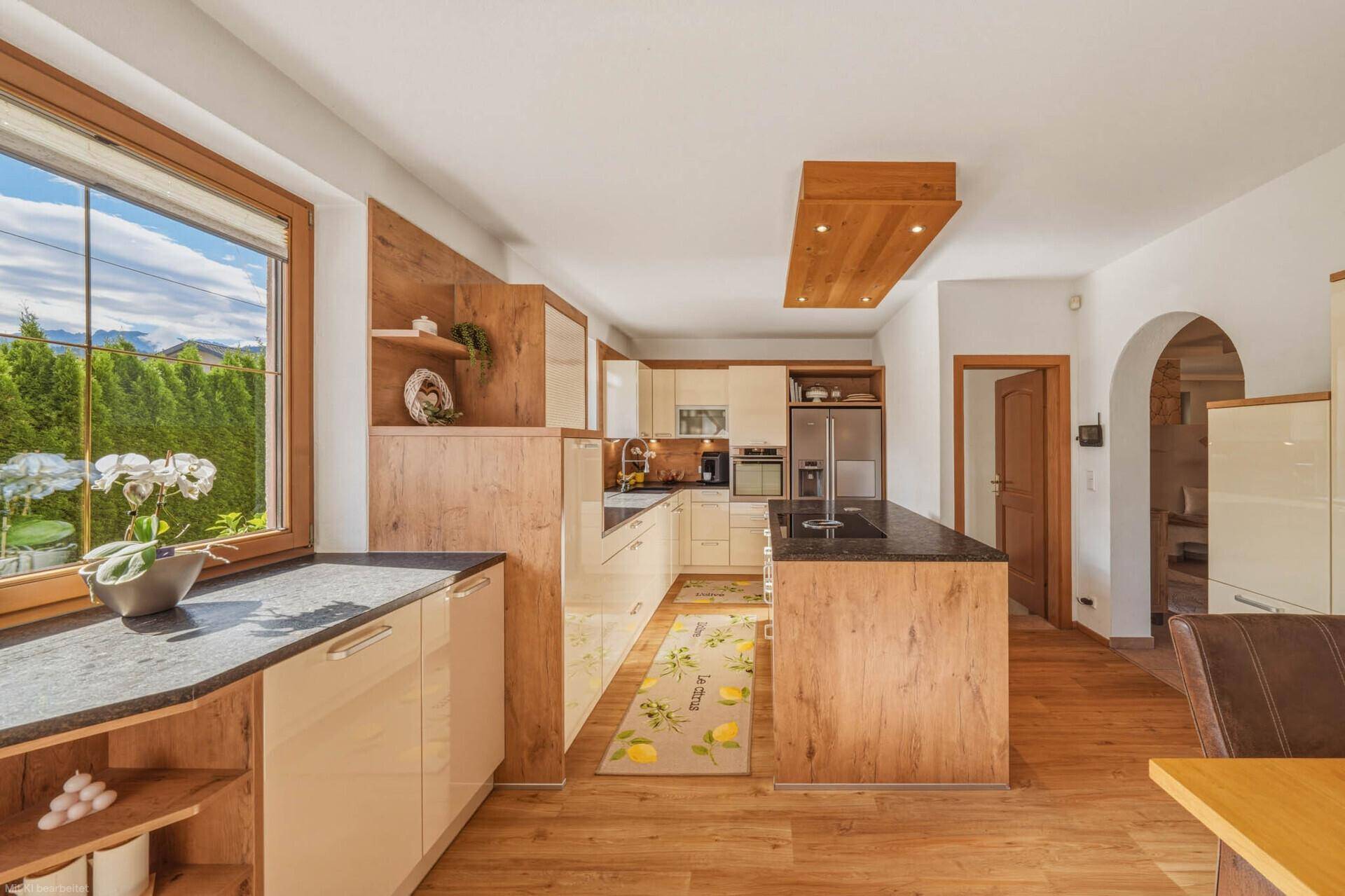Helle Einbauküche mit Holz- und Cremetönen, Granitarbeitsplatten und großem Fenster.