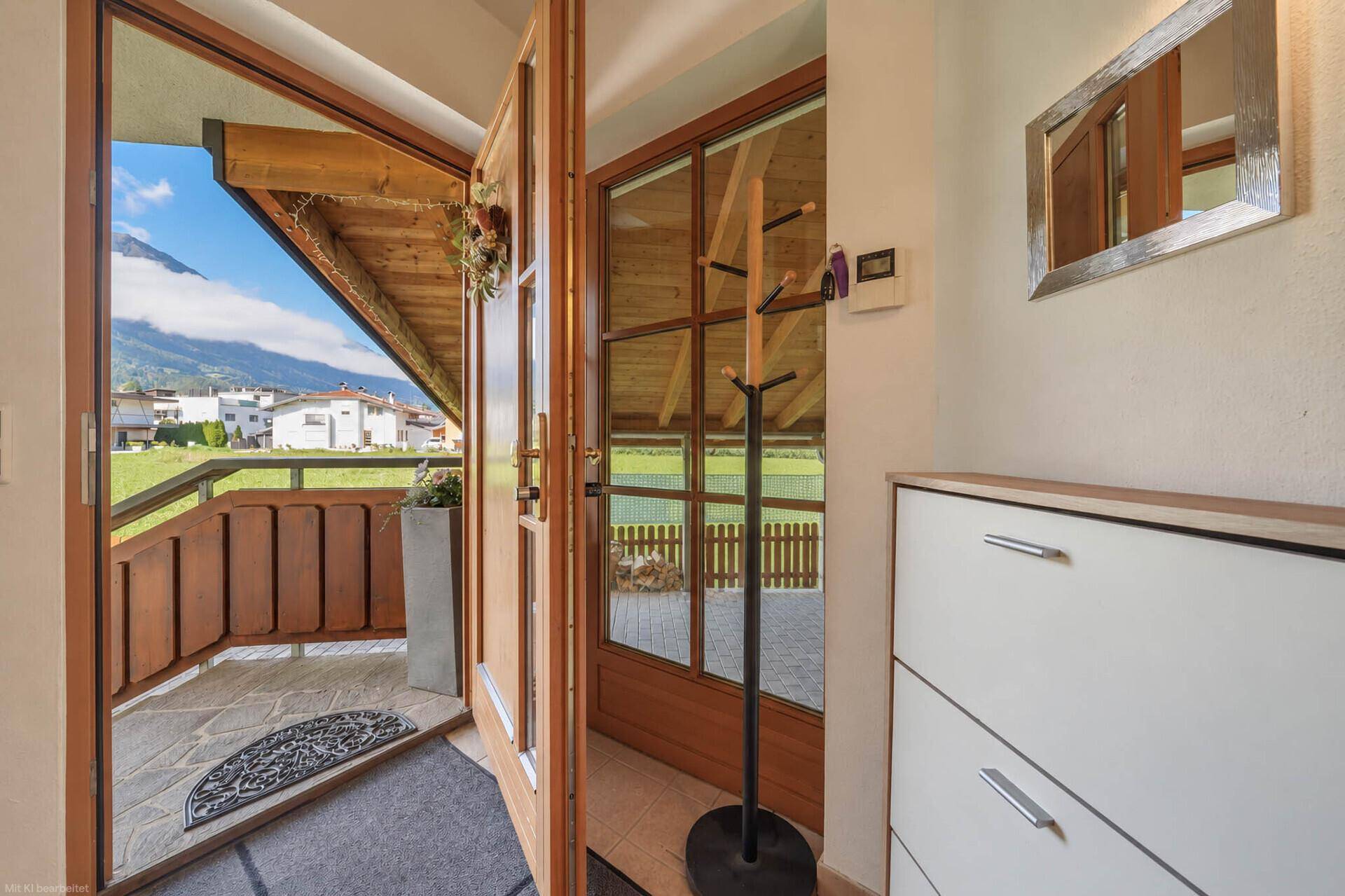 Freundlicher Eingangsbereich mit Schuhschrank, Garderobe und Blick ins Grüne.