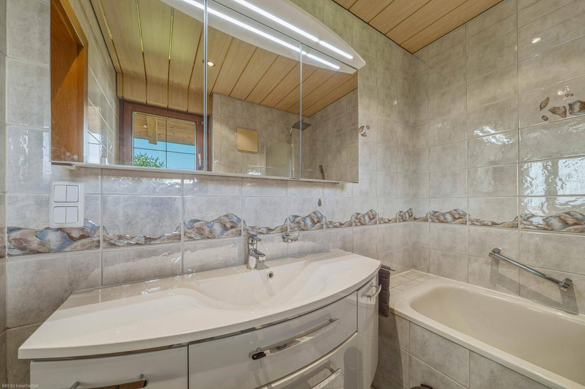 Badezimmer mit modernem Waschtisch, Spiegelschrank und Badewanne.