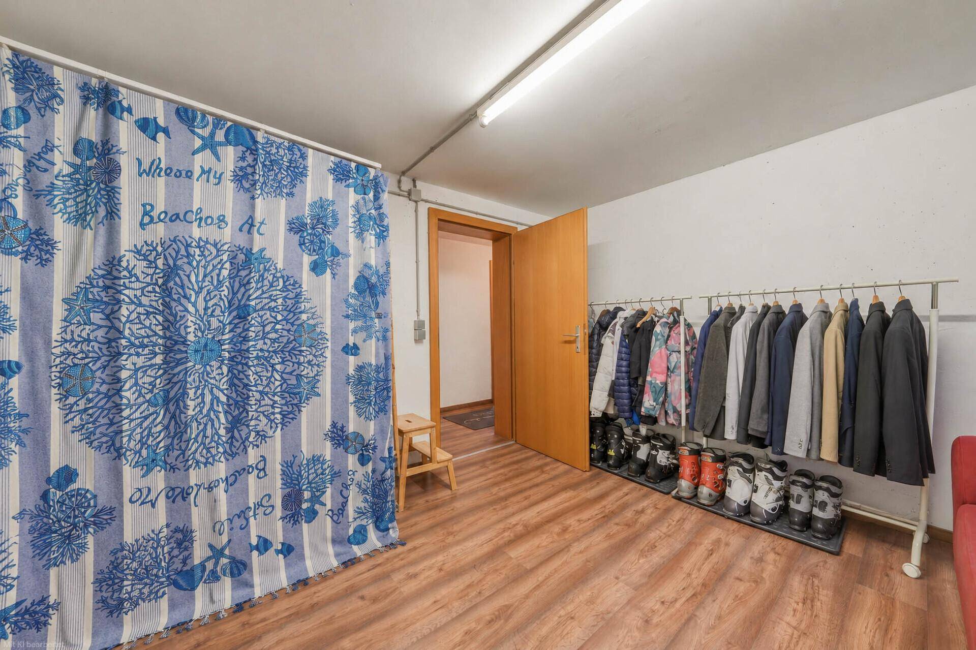 Praktischer Abstellraum im Untergeschoss mit Kleiderstange und Schuhregal, ideal für Garderobe.