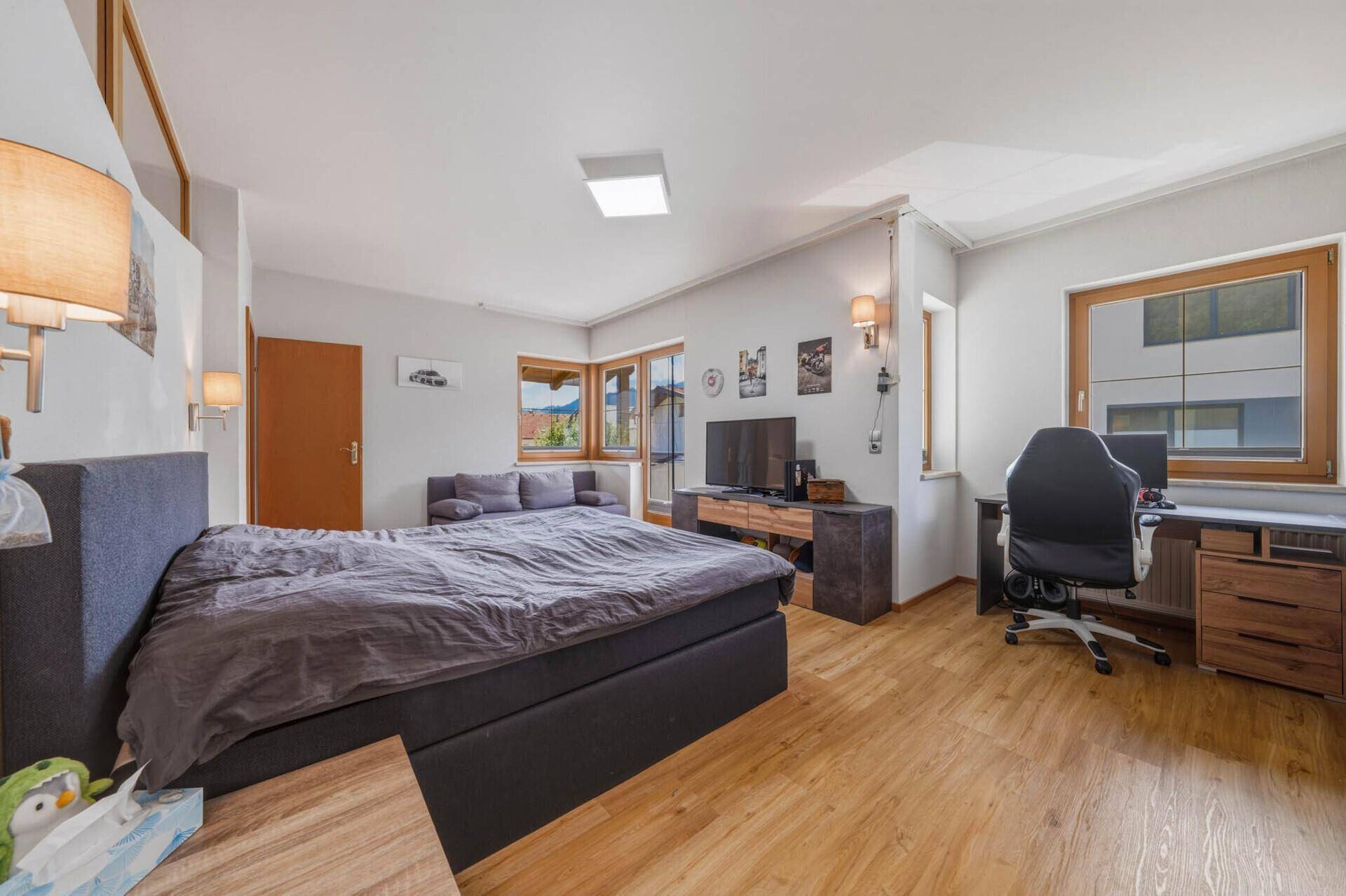 Geräumiges Schlafzimmer mit Doppelbett, Schreibtisch und Blick ins Grüne.