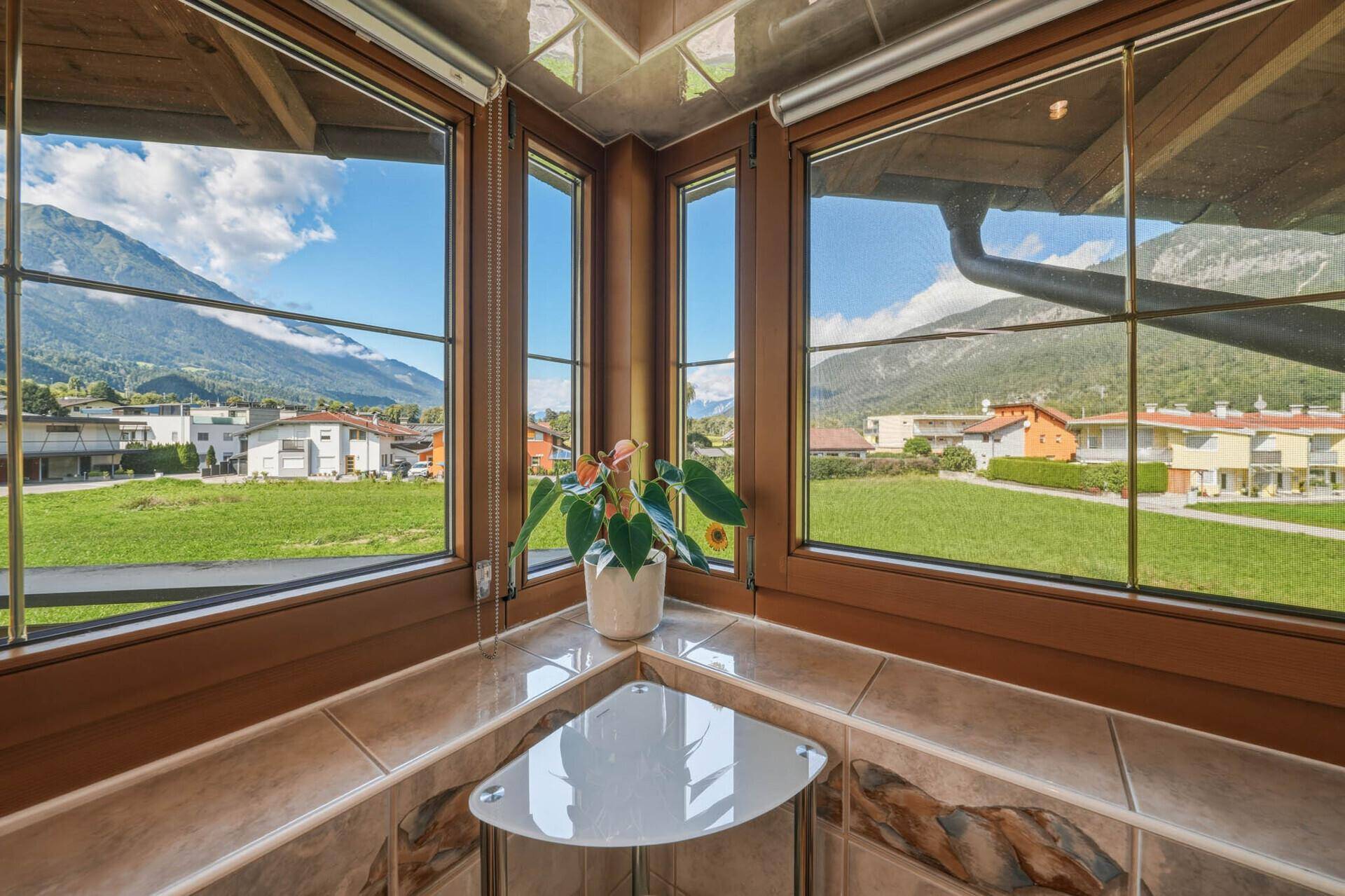 Eckfenster mit weitem Blick auf die Berge und die grüne Umgebung.