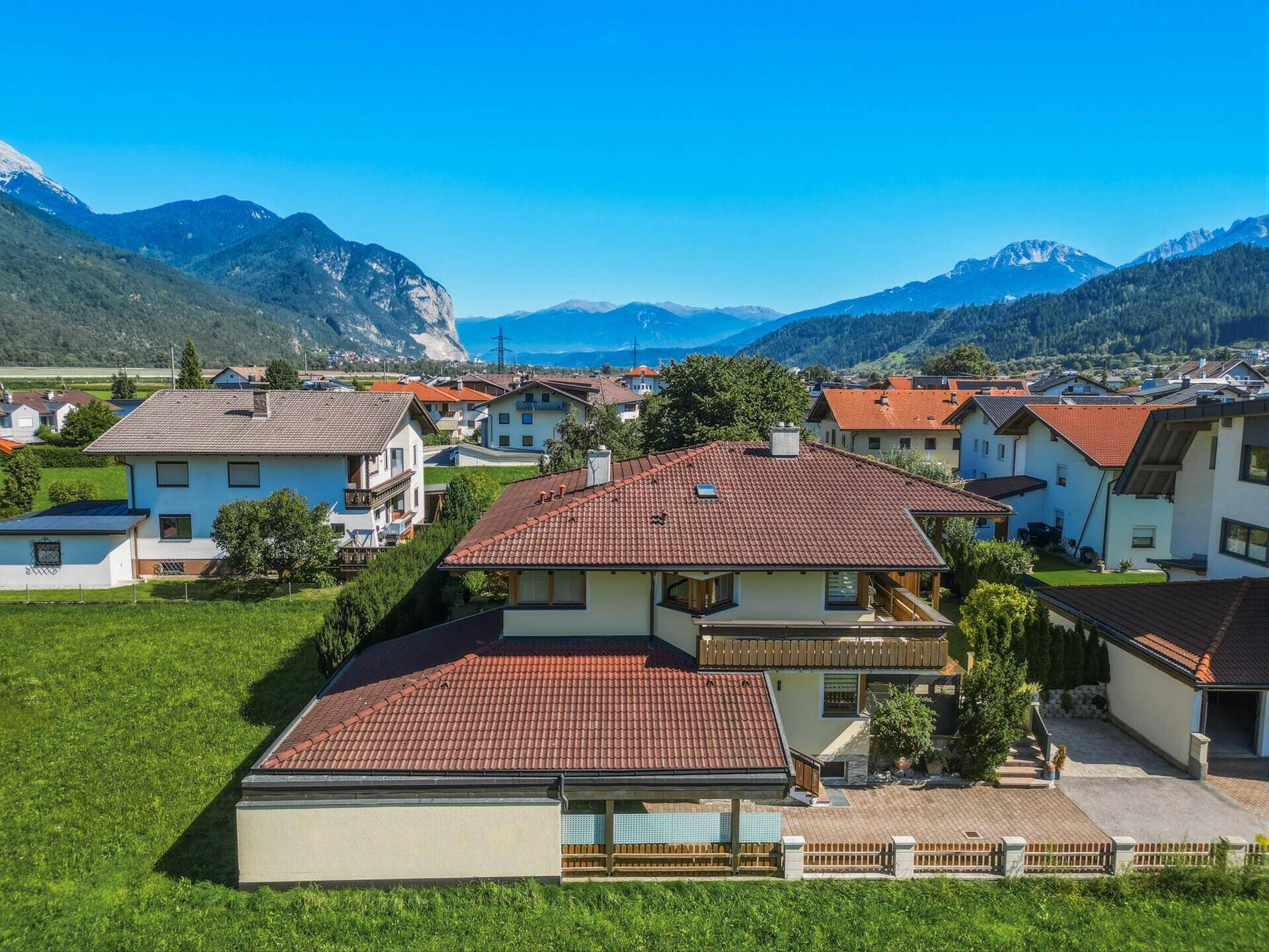 Luftaufnahme des Hauses und der Nachbarschaft, eingebettet in eine malerische Berglandschaft.
