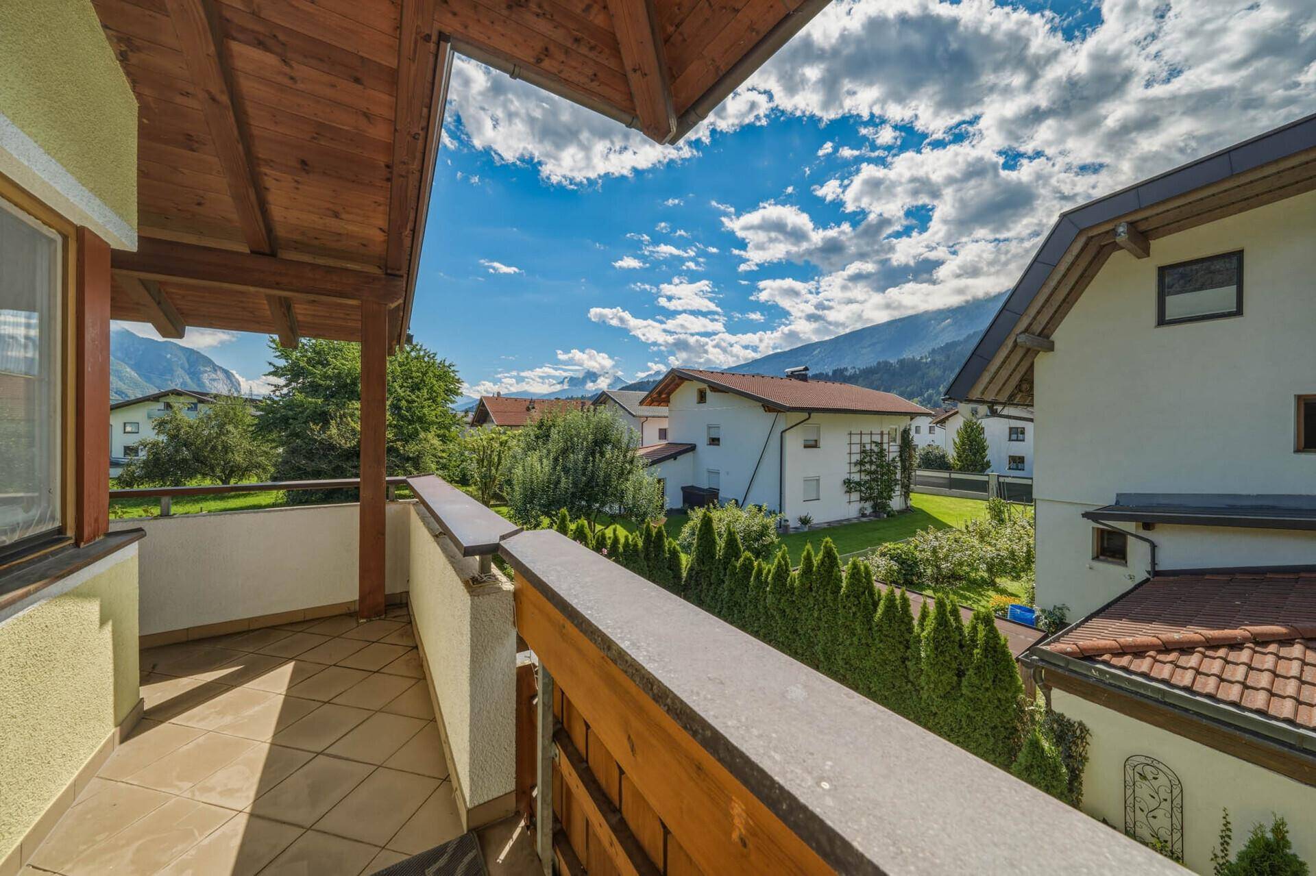 Sonniger Balkon mit Bergblick und grüner Umgebung, ideal zum Verweilen.