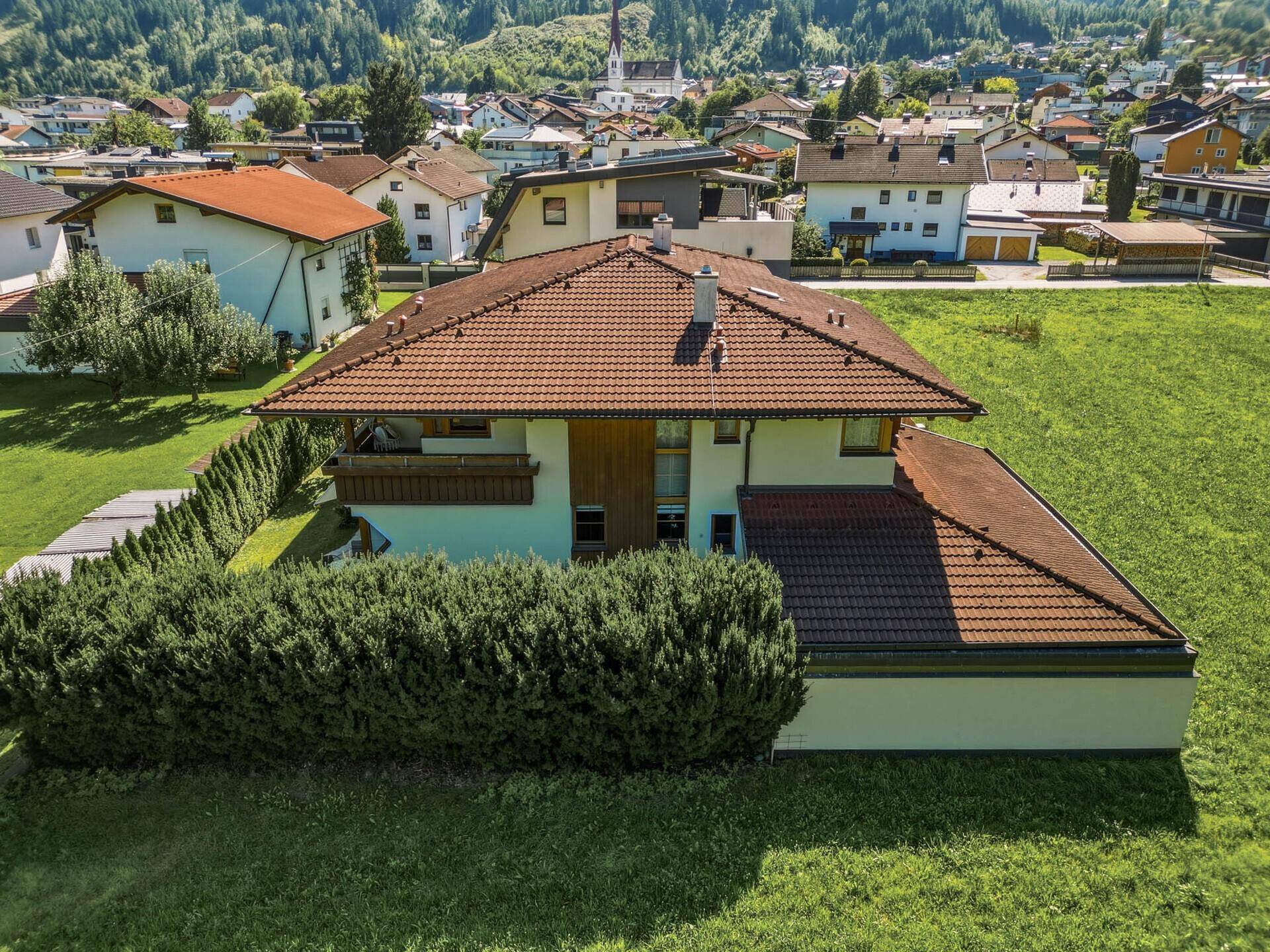 Luftaufnahme des Hauses von hinten, mit gepflegtem Garten und Blick auf die Nachbarschaft.
