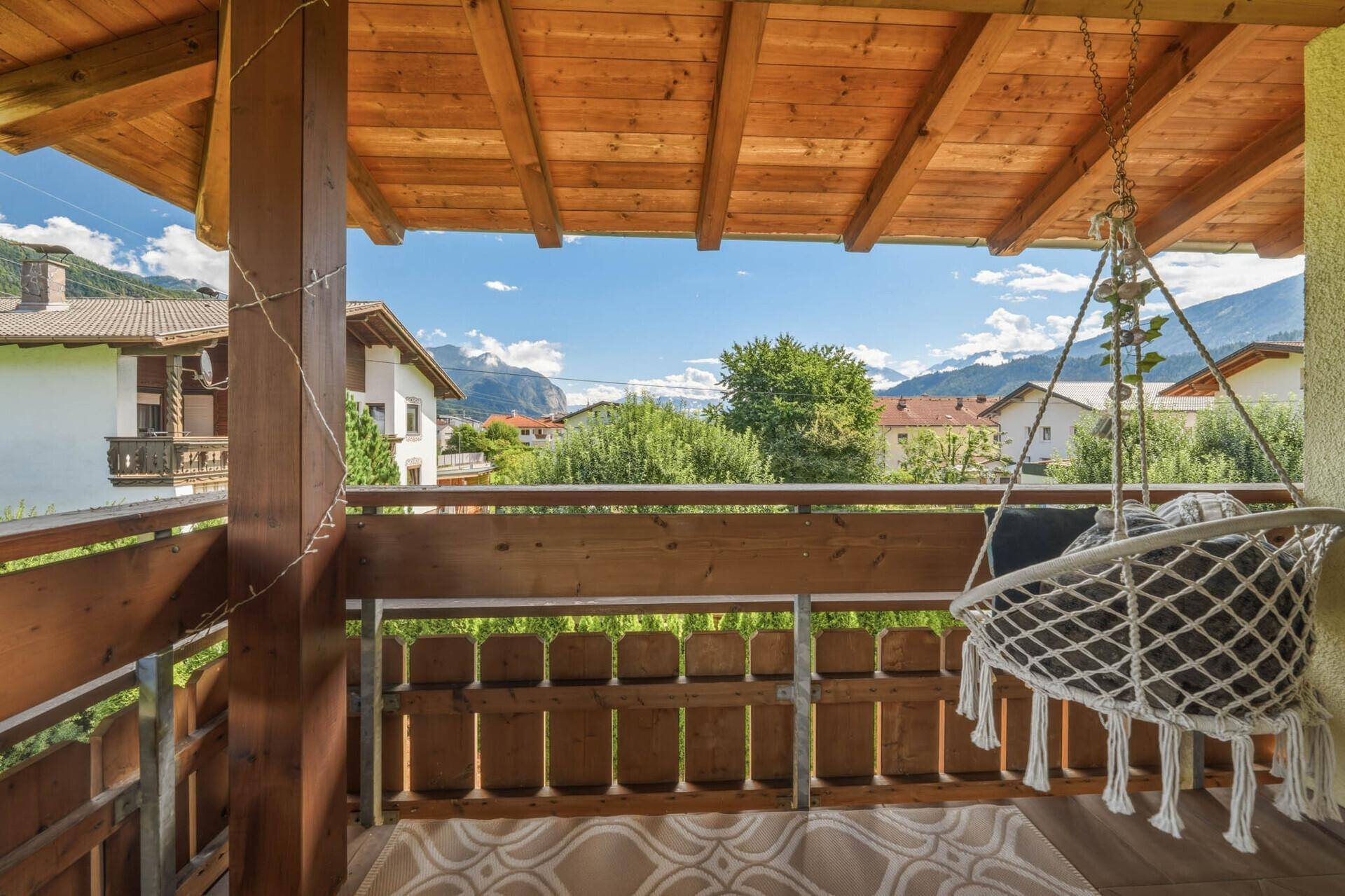 Gemütlicher Balkon mit Hängesessel und weitem Blick auf die Berge.