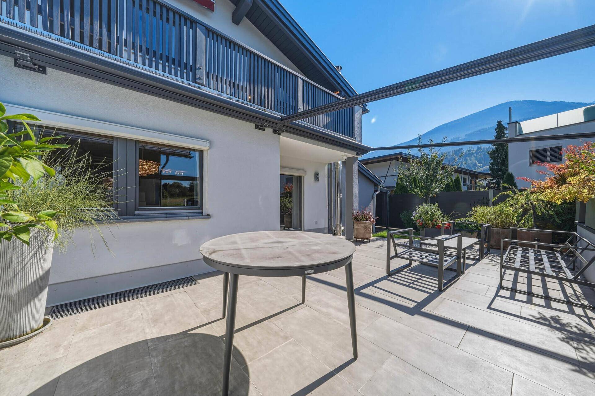 Große Terrasse mit Esstisch, Lounge-Bereich und Blick auf die umliegenden Berge.