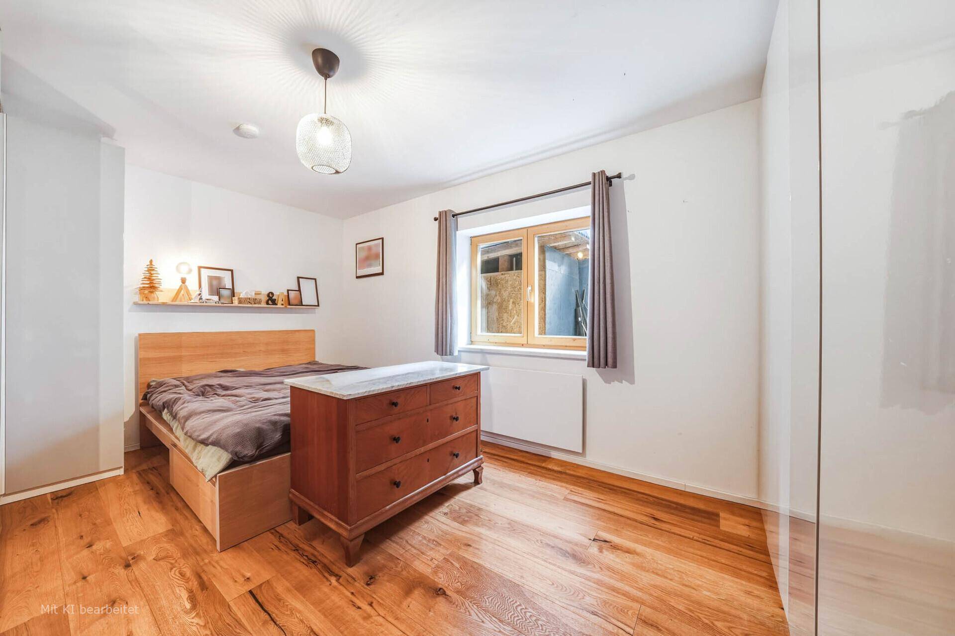 Gemütliches Schlafzimmer mit Holzbett, antiker Kommode und Fenster für natürliches Licht.