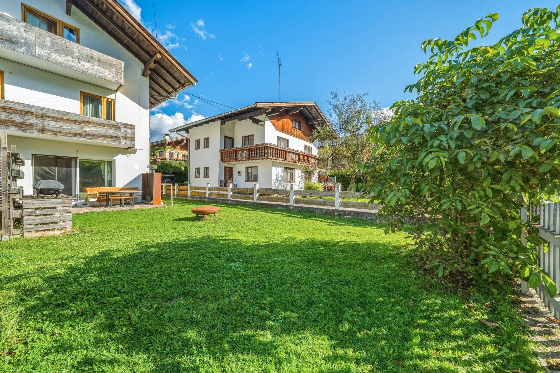Weitläufiger Gartenbereich mit gepflegtem Rasen und Blick auf das charmante Wohnhaus.