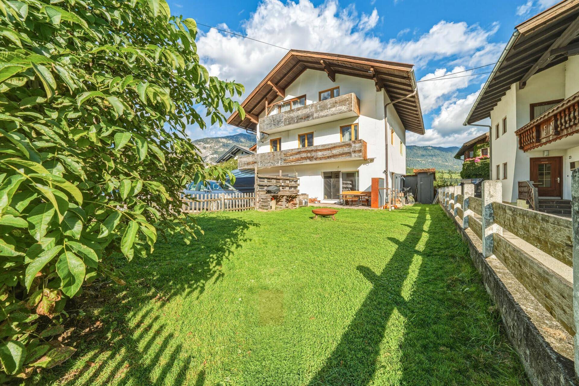 Großzügige Rasenfläche neben dem Wohnhaus mit Blick auf die umliegende Landschaft.