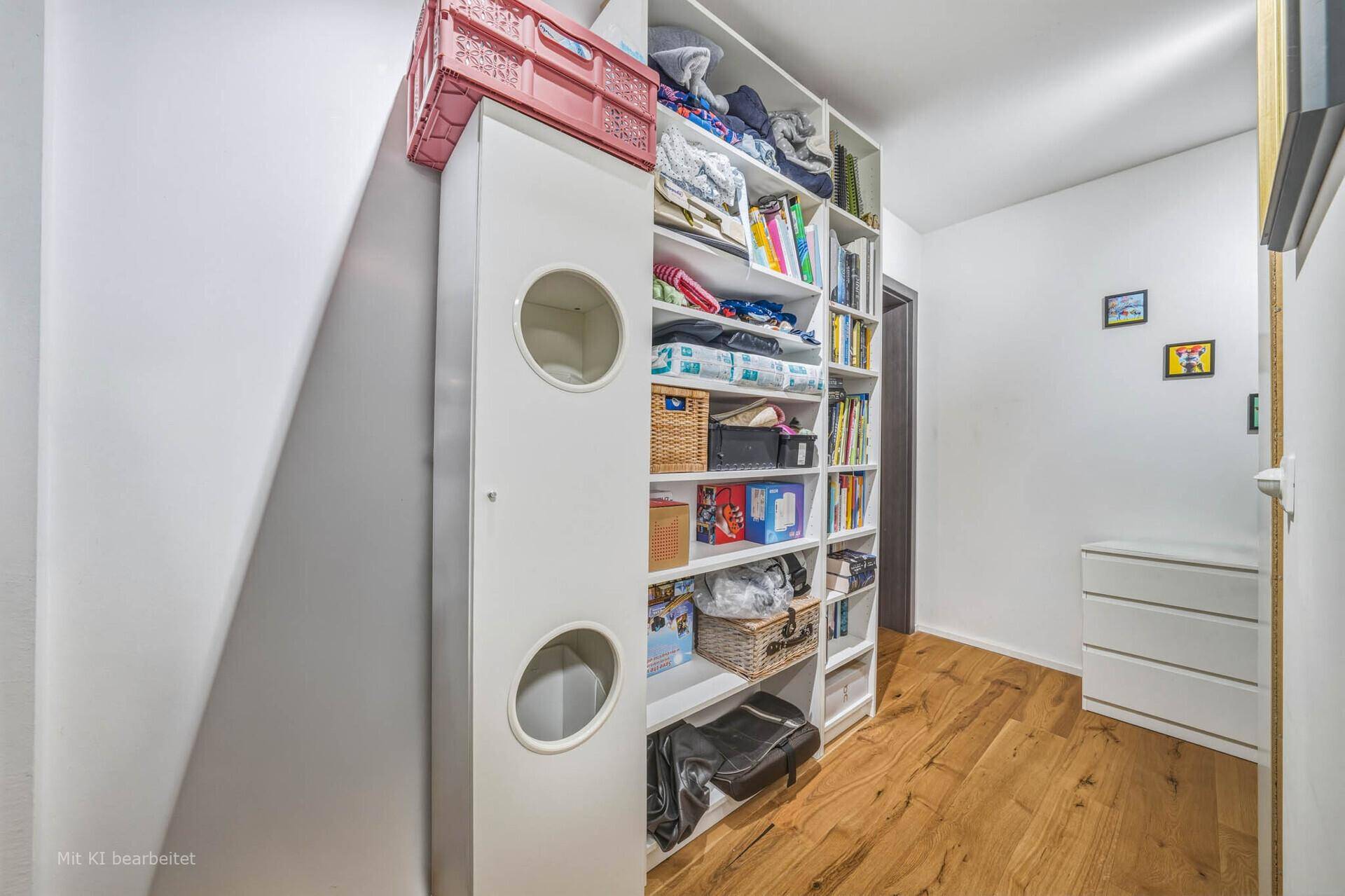Heller Flur mit hohem weißen Schrank und Bücherregal, bietet viel Stauraum.