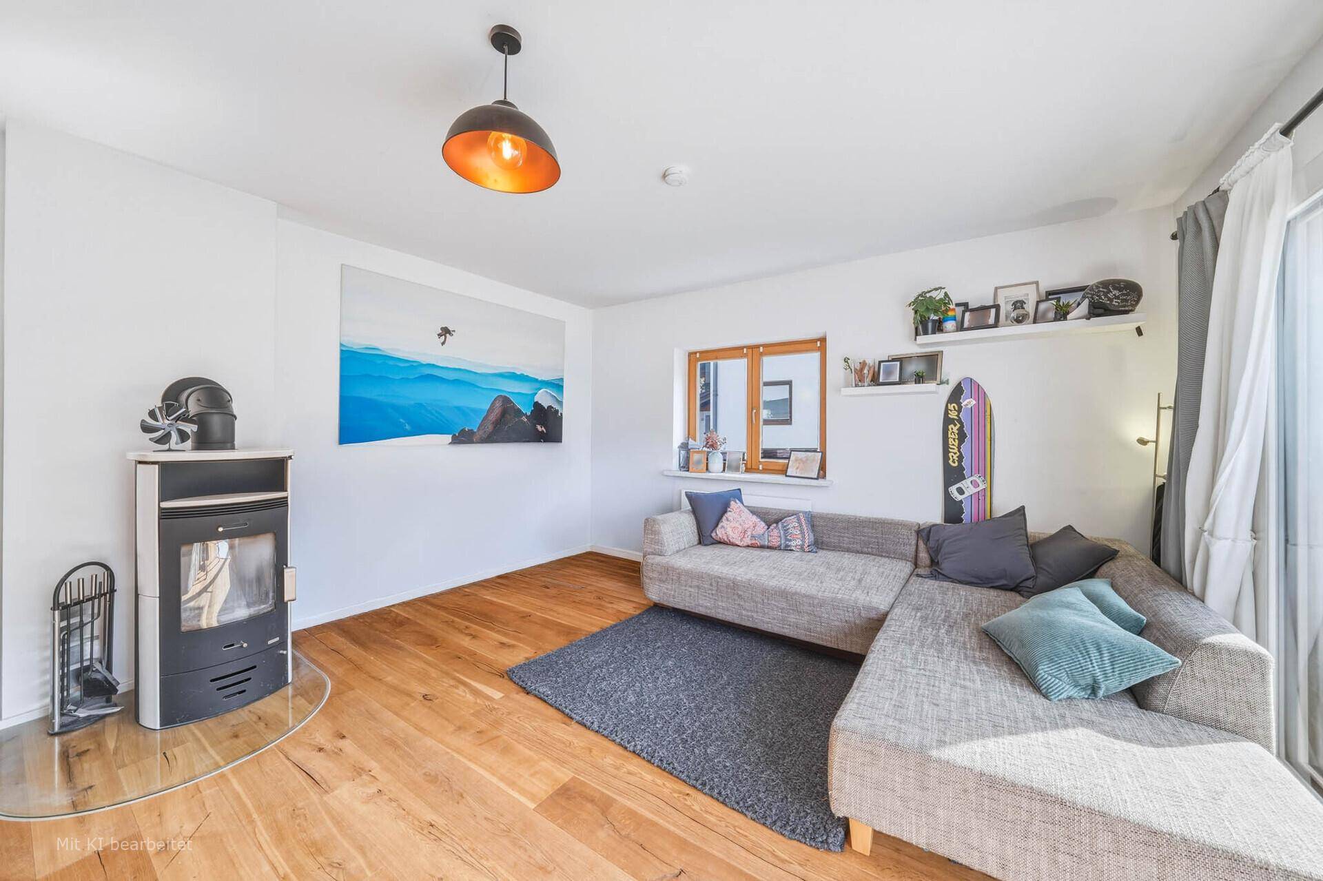 Modernes Wohnzimmer mit Kaminofen, Ecksofa und Holzboden, ideal für gemütliche Abende.