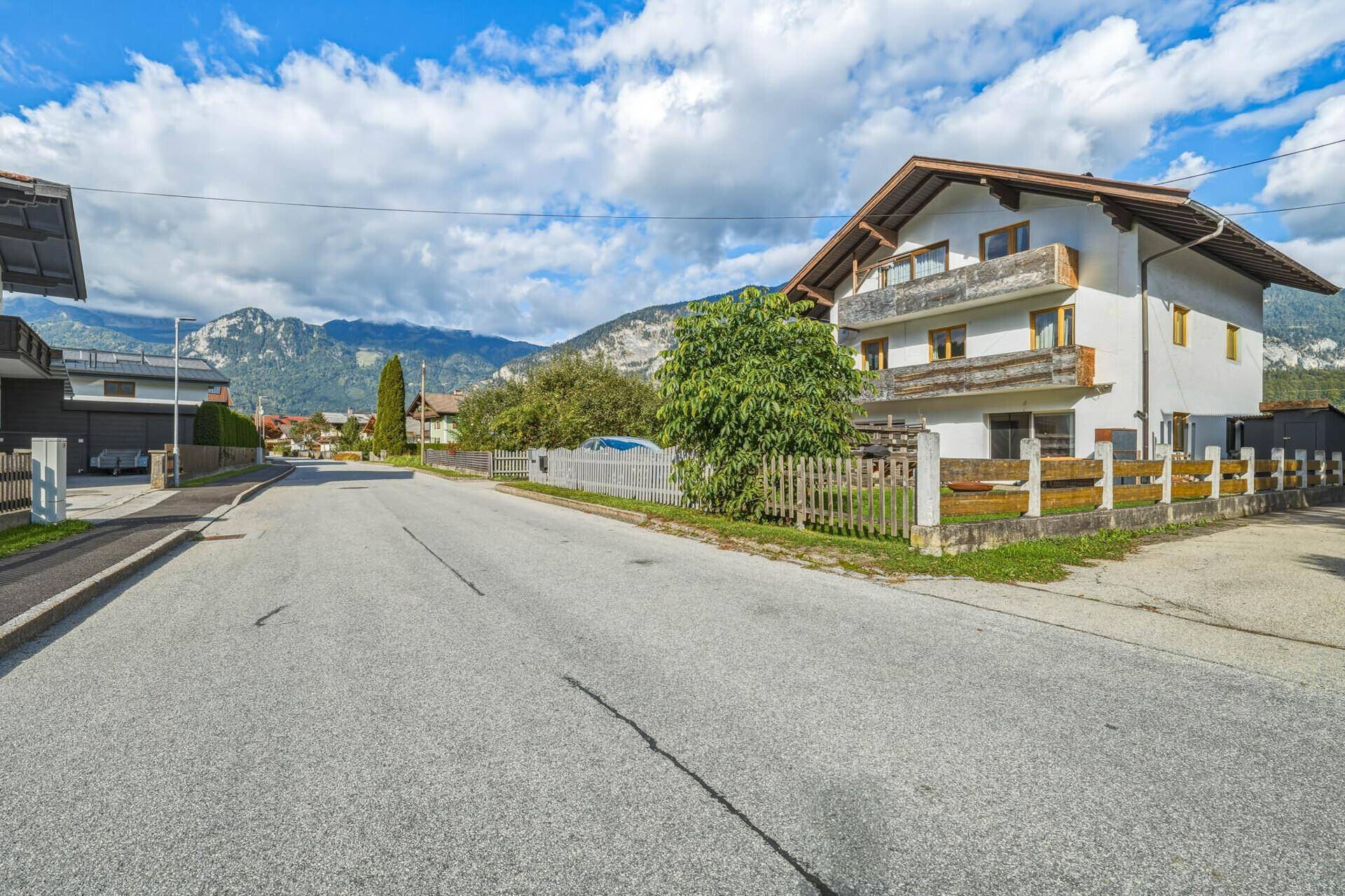 Ruhige Wohnstraße mit Blick auf die umliegenden Berge und das Einfamilienhaus.