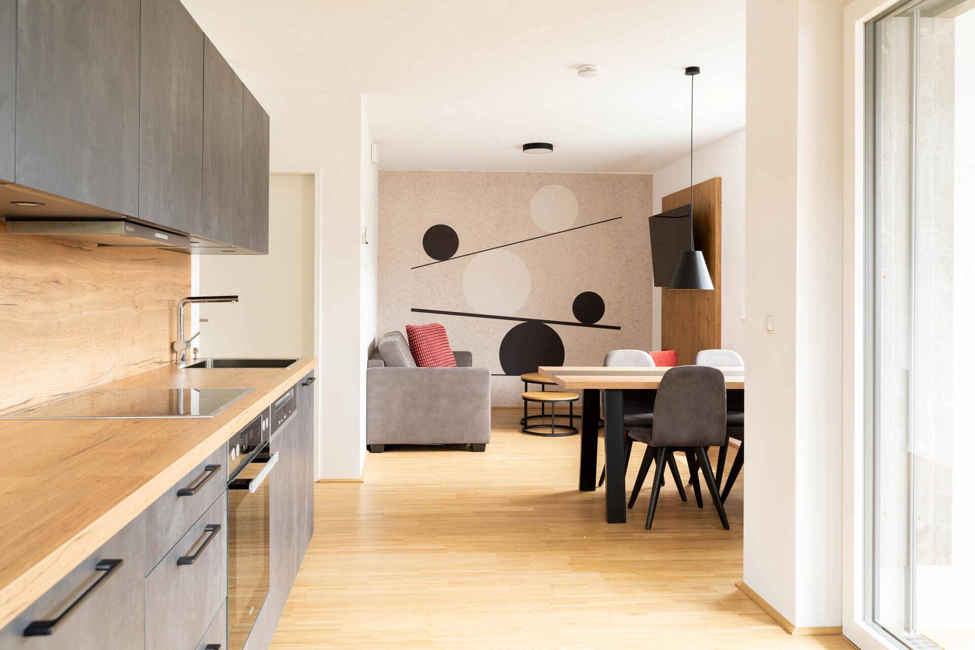 Balkon mit Holzboden, Sitzgelegenheiten und Blick auf die umliegende Landschaft.