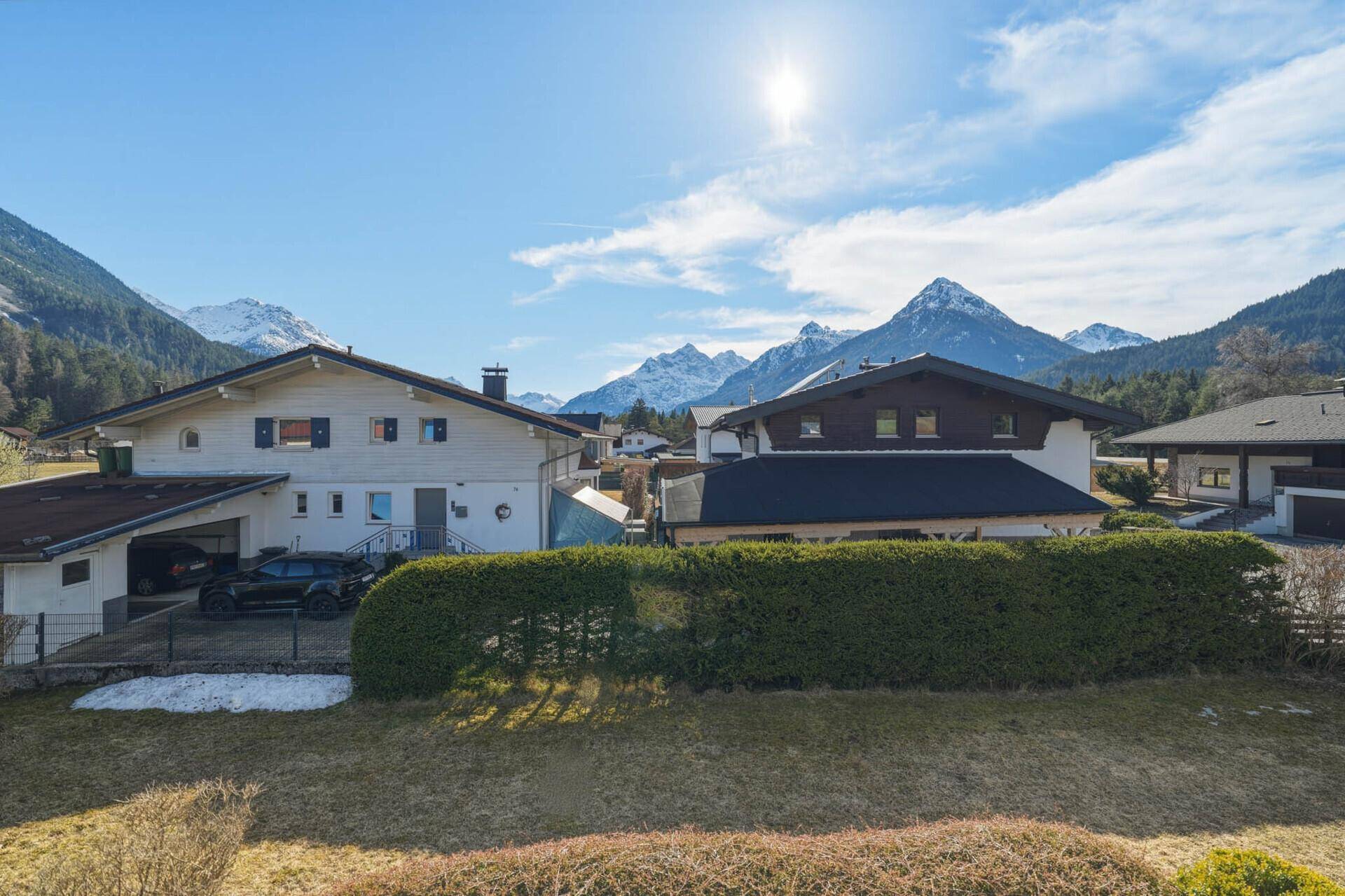 Panoramablick auf die majestätische Berglandschaft und die umliegenden Häuser.