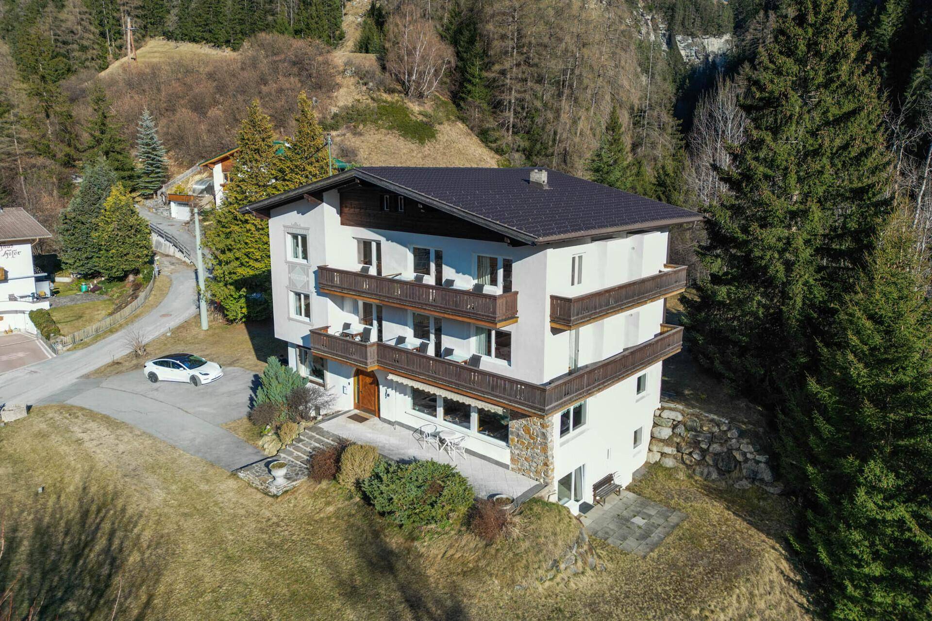 Luftaufnahme des Wohnhauses in alpiner Umgebung mit umliegenden Wäldern.