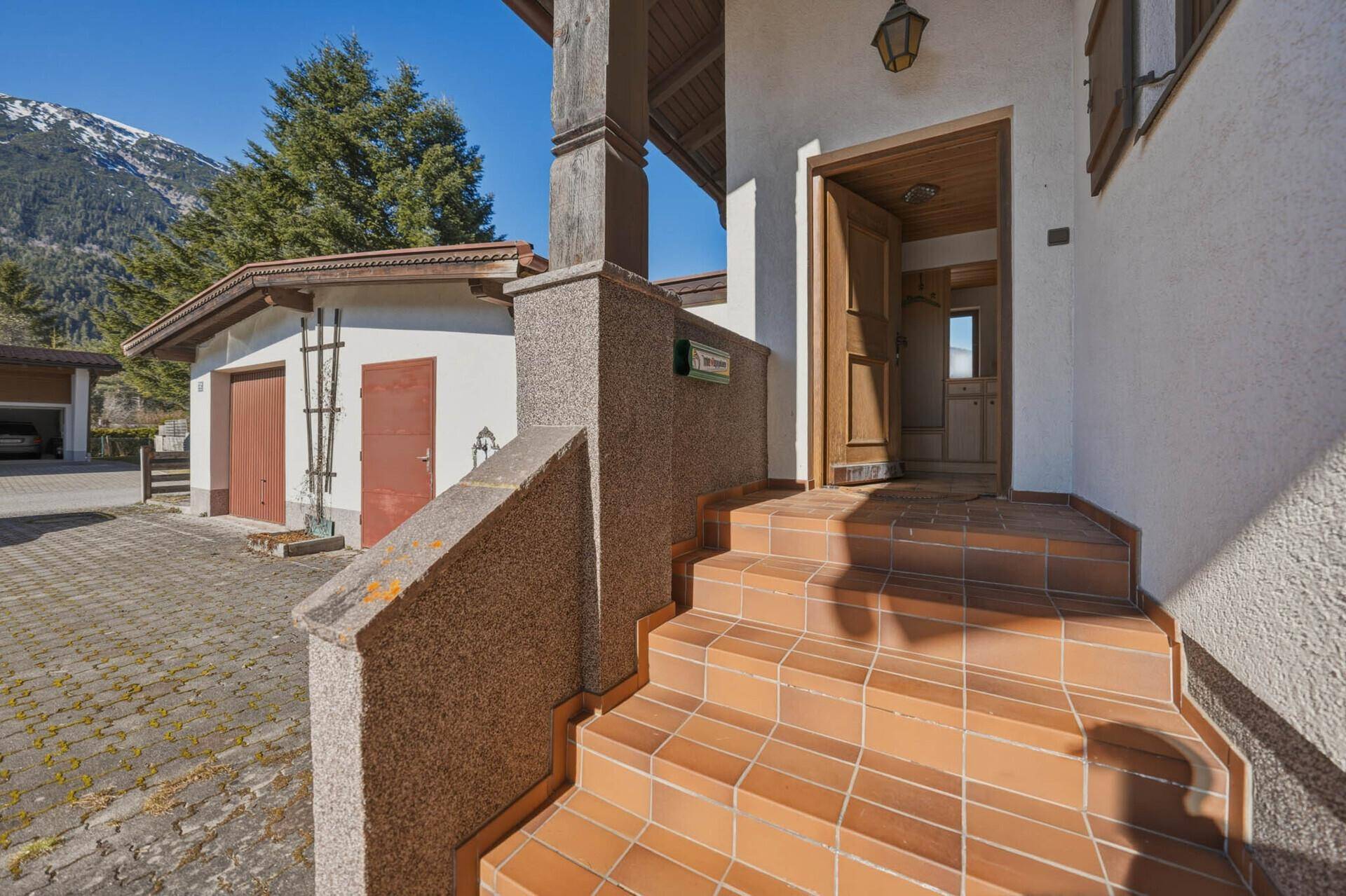 Hauseingang mit gefliester Treppe und traditioneller Architektur.